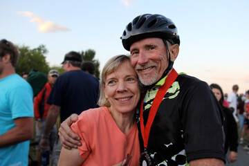 mature couple embrace at finish of cycling race