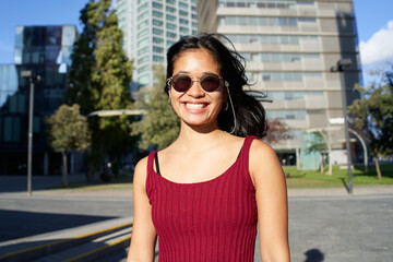 Portraits of a charming Asian Woman looking at the camera with sunglasses. Girl posing for the camera in the city center. High quality photo