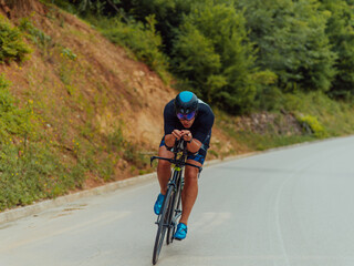 Full length portrait of an active triathlete in sportswear and with a protective helmet riding a bicycle. Selective focus 
