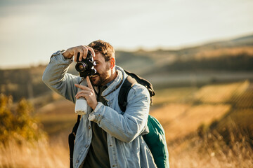 Young photographer hiking on mountains and photographing nature.