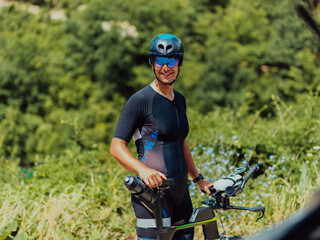 Close up photo of an active triathlete in sportswear and with a protective helmet riding a bicycle....