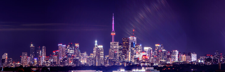 Naklejka premium Toronto skyline at night with buildings street lights. Toronto, Ontario, Canada. Down town city skyline and panorama with urban areas. Sky with lights leaks.