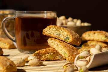 Biscotti Cantuccini Cookie Biscuits with pistachios and lemon peel Shortbread. Cup of tea. Teatime break Healthy eating food. Homemade fresh Italian cookies cantucci stacks and organic pistachios nuts