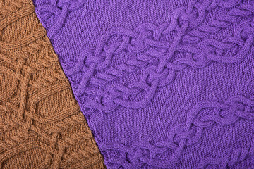 Knitted lilac and brown background. Large knitted fabric with a pattern. Close-up of a knitted blanket.