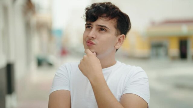 Non binary man standing with doubt expression at street