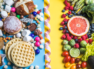 Healthy and unhealthy food concept. Fruit and vegetables vs sweet top view flat lay on rustic background