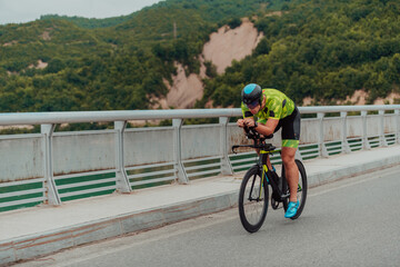 Full length portrait of an active triathlete in sportswear and with a protective helmet riding a bicycle. Selective focus 