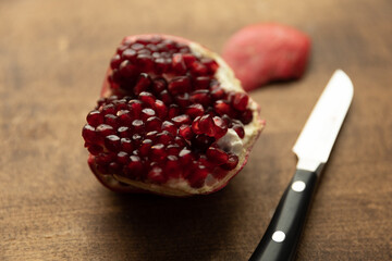 Fresh pomegranate cut open on cutting board