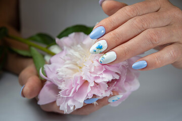 girl with a beautiful white blue manicure with a bouquet of delicate peonies, 