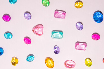 Colorful gemstones on pastel light pink background. Abundance concept. Fun and wellbeing idea.