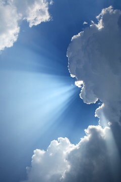 Dramatic light rays (crepuscular rays) escape from behind a cloud. Sometimes known as the