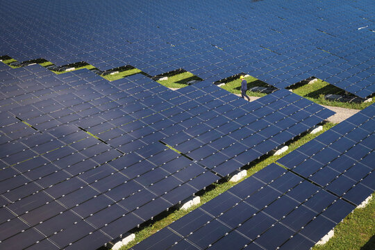 An electrician walking in a large solar panel farm in Northfield, Massachusetts.