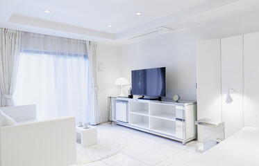 Sunny white living room with TV, entertainment center, sofa, and table