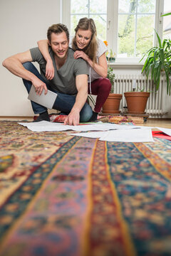 Couple looking at map in living room, Munich, Bavaria, Germany