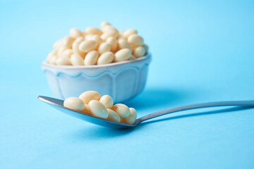 Probiotic and lactobacillus capsules on a bowl with a blue background
