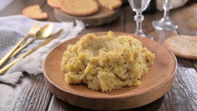 polenta with porcini mushrooms, bacon, served on a dark wooden background. Typical food of northern Italy, Trentino in the Alps . 4k