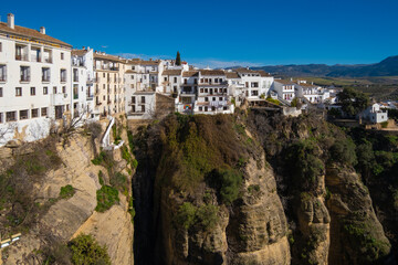 Fototapeta na wymiar Houses built on the edge of the cliff, in the ancient city of Ronda, Spain