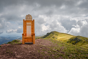 Wooden throne on Midzor, highest peak of Stara planina (Balkan mountains) in Serbia under dramatic sky and light - 565489663