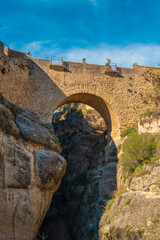 Fototapeta na wymiar The Old Bridge (Puente Viejo) and the Ronda Gorge (Tajo de Ronda) on the Guadalevin River. Andalusia, province of Malaga, Spain