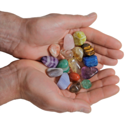 Male Crystal therapist with cupped hands filled with a selection of multicoloured healing tumbled gem stones transparent png file	