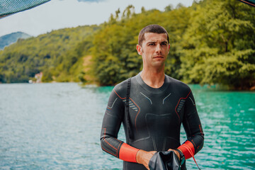 Athlete putting on a swimming suit and preparing for triathlon swimming and training in the river...
