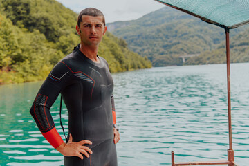 Athlete putting on a swimming suit and preparing for triathlon swimming and training in the river...