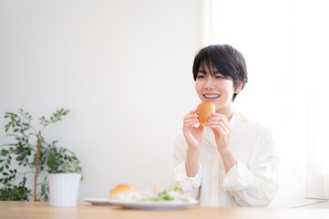 Asian woman eating bread A fresh breakfast scene with a beautiful morning sunrise