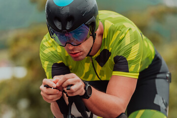 Close up photo of an active triathlete in sportswear and with a protective helmet riding a bicycle....