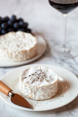 Camembert french cheese served with red wine glass and grapes