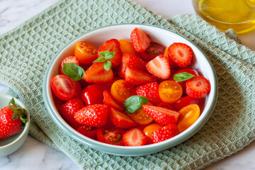 Strawberry, tomato cherry and basil leaves salad