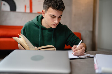 Naklejka premium Young man caucasian teenager read book study at home education concept