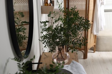 Eucalyptus branches and towel on bathroom vanity. Interior design