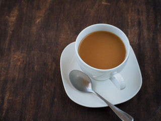Obraz premium White cup latte coffee on vintage wooden table in morning