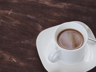 White cup latte coffee on vintage wooden table in morning