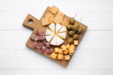 Toothpick appetizers. Pieces of sausage, cheese and olives on white wooden table, top view