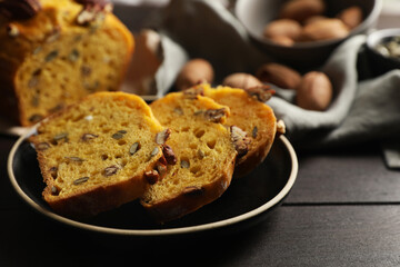Cut pumpkin bread with pecan nuts on wooden table, closeup
