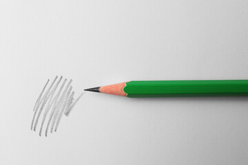 Sharp graphite pencil and hand drawn scribble on white sheet of paper, top view