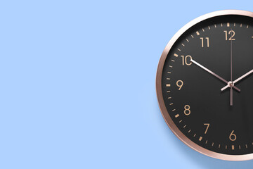 Stylish round clock on light blue background, top view with space for text. Interior element