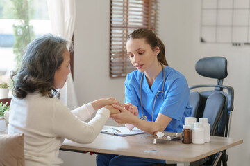 Obraz premium Female doctor taking a history of a patient and counseling on orthopedic diseases with female patients after measuring blood pressure and heart rate in a medical facility