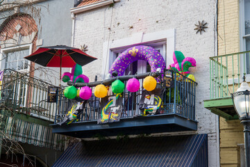 mardi gras on a blue metal balcony with a tall black light post and green metal balconies on a brick buildings in Mobile Alabama USA © Marcus Jones