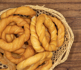 Pieces of traditional Latin American pastry called ROSQUITAS DE SAL or ROSCAS made with wheat flour. Top view of Neapolitan cookies called TARALLI. Stale salt bagels. Wood table. Ecuador