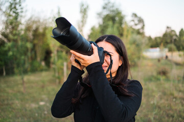 Young amateur photographer woman practicing photography to improve her mental health. Telephoto lens