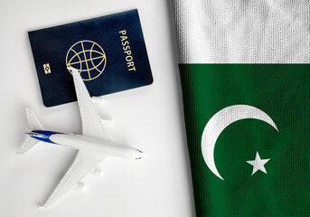 Flag of Pakistan with passport and toy airplane. Flight travel concept
