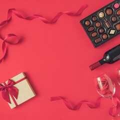Composition Valentines day background with wine bottle, gift box, glasses and box of chocolates. Minimal concept of Valentine's Day or love. Creative art, minimal aesthetics. Top view. Flat lay