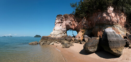 Hole in the rock. Panoramic view of Laem Chamuk Khwai Rock and Beach on sunny day. Thalane, Krabi Province, Thailand.