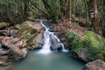 Long exposure shot of a cascede on the creek in the forest on cloudy day. Dragon's Crest (Ngon Nak) hiking trail, Krabi Province, Thailand.