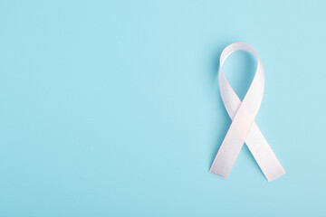 Pink ribbon on blue background. Breast cancer treatment concept.