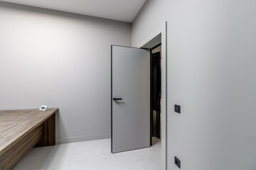 A simple modern gray wall with a black and gray door in an empty room. Interior design element of modern interior design in a modern house