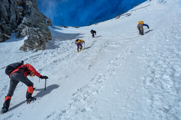 Fototapeta na wymiar 雪の木曽駒ヶ岳、ピッケルとアイゼンを使い八丁坂を登る登山者