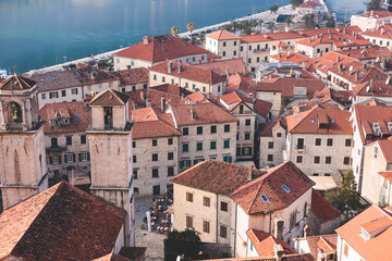 Fototapeta premium Kotor, Montenegro, beautiful top panoramic view of Kotor city old medieval town seen from San Giovanni St. John Fortress, with Adriatic sea, bay of Kotor and Dinaric Alps mountains in a sunny day